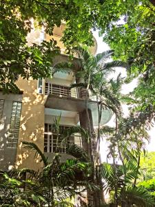 a building with a balcony with trees in front of it at Rio Monte Residence in Bangkok