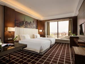 una camera d'albergo con due letti e una grande finestra di Royal Century Hotel Shanghai a Shanghai