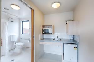 a small kitchen with a sink and a microwave at Bella Vista Motel Rotorua in Rotorua +43 photos