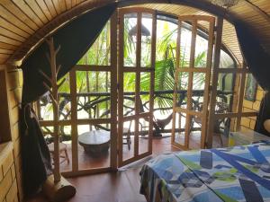 um quarto com uma grande janela com uma cama em Hotel Cabaña Guainiana em Inírida