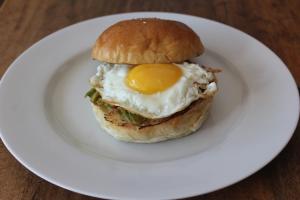 a sandwich with an egg on a white plate at Mahi Mahi House in Nusa Lembongan