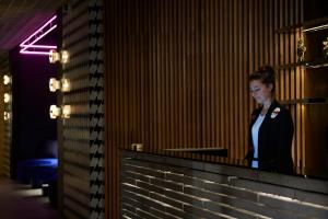 a woman standing behind a counter in a room at Tribe Perth in Perth