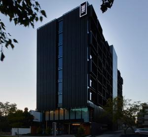 Un edificio alto y negro con un cartel. en Tribe Perth en Perth