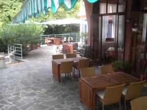 a patio with wooden tables and chairs in a restaurant at Hotel Esperia in Genoa