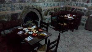 a table and chairs in a room with a fireplace at California Guest House in Gori