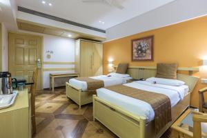 Postel nebo postele na pokoji v ubytování The Royal Orchid Hotel, Chembur