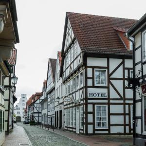 une rangée de bâtiments noirs et blancs dans une rue dans l'établissement Historik Hotel Garni Christinenhof, à Hameln