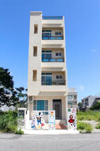 a tall white building with graffiti on it at Na Na Ya Ji Bed and Breakfast in Taitung City