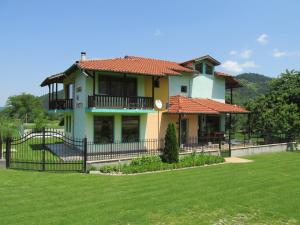 une maison avec une clôture devant une cour dans l'établissement Pri Orehite Guesthouse, à Oreshak