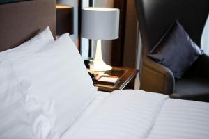 a bedroom with a bed and a chair and a lamp at Jianguo Hotel in Beijing
