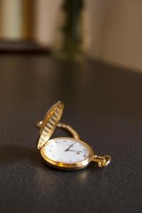 a gold pocket watch sitting on a table at Bed & Breakfast Vila Baguc in Split