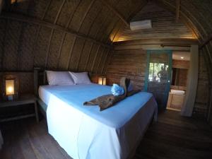 a bedroom with a large bed in a cabin at Gili Kulemba Bungalow in Gili Trawangan