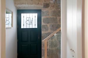 a black door in a hallway with a brick wall at Bed & Breakfast Vila Baguc in Split