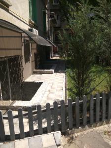 a fence in front of a building with a tree at Studios on Grigore Vieru in Chişinău