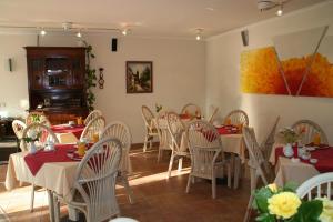 a dining room with tables and chairs and a painting at Pension Villa Beer in Stralsund