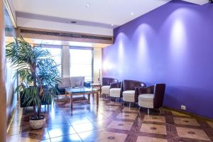 a waiting room with chairs and a potted plant at The Royal Orchid Hotel, Chembur in Mumbai