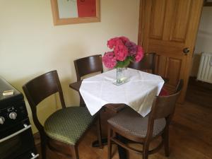 a dining room table with a vase of flowers on it at Assaroe House in Ballyshannon