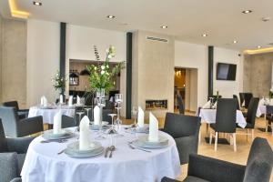une salle à manger avec des tables et des chaises blanches dans l'établissement Apartamenty Katowice by Lantier - Bytom - Chorzów, à Bytom