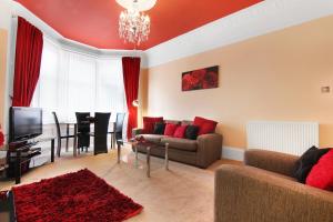 una sala de estar con un sofá y una mesa en Townhead Apartments Glasgow Airport, en Paisley