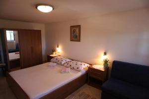 um pequeno quarto com uma cama e um sofá em Accommodation Lily em Vrana