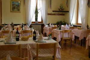 una sala da pranzo con tavoli e sedie con tovaglia rosa di Albergo Sud America a Paesana