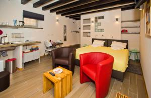 una camera con letto giallo e sedia rossa di St. Stephen's Square Apartment a Hvar