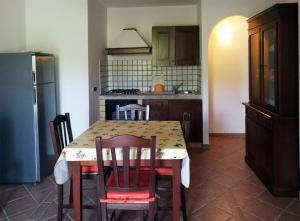 ムルタ・マリアにあるResidence degli uliviのキッチン(テーブル、椅子、冷蔵庫付)