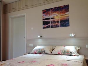 ブルガスにあるBeachfront Sea Garden Apartmentのベッドルーム1室(壁に絵画が描かれたベッド1台付)