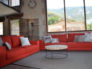Belvilla by OYO Cobert de l Era في Oden: غرفة معيشة مع أريكة حمراء وطاولة