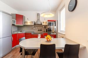 カルロヴィ・ヴァリにあるModern Apartment with 2 bedroomsのキッチン(赤いキャビネット、フルーツ付きのテーブル付)