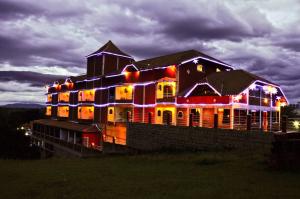 a large house is lit up with christmas lights at Hotel do Papai Noel in Penedo