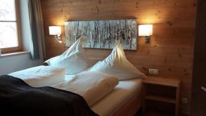 ブリクセン・イム・ターレにあるHaus Waldeggのベッドルーム1室(ベッド2台、壁に照明2つ付)