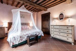 a bedroom with a bed with a canopy at Borgo Cerbaiola in Montecastelli