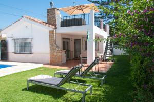 a villa with a pool and two lawn chairs at Villa Marysol sleeps 6 in Fuengirola