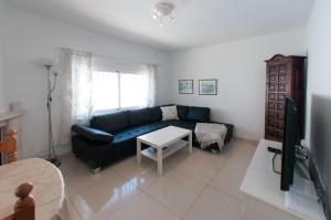 a living room with a blue couch and a tv at Villa Marysol sleeps 6 in Fuengirola