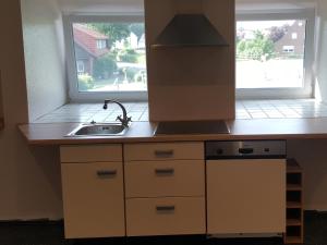 cocina con fregadero y ventana en Pension Citytravel, en Espelkamp-Mittwald