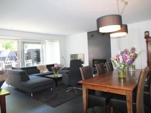 een woonkamer met een bank en een tafel bij Modern spacious holiday home with lovely backyard and veranda in Limmen in Limmen