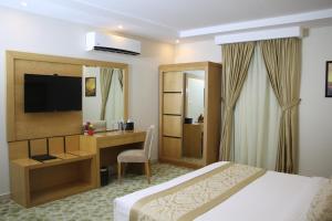 アル・カフジにあるAlMuhaidb Residence Alkhafjiのベッドとデスクが備わるホテルルームです。