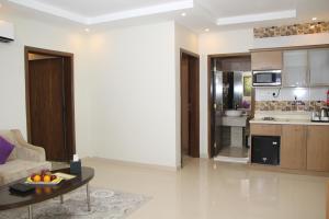 a living room with a table and a kitchen at AlMuhaidb Residence Alkhafji in Al Khafji