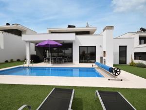 a villa with a swimming pool in front of a house at Modern villa with private swimming pool near Nazar in Famalicão