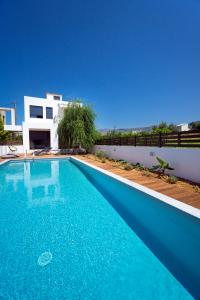 a blue swimming pool in front of a house at Seametry Luxury Living Villa in Chania Town