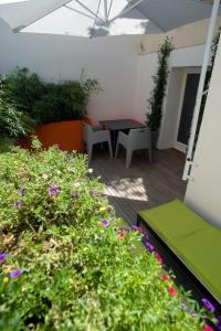 a patio with a table and some plants and flowers at Villa des Canuts in Lyon