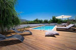 a swimming pool with two lounge chairs and an umbrella at Seametry Luxury Living Villa in Chania