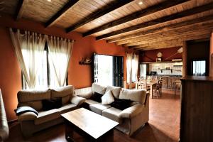een woonkamer met twee banken en een tafel bij Casa Rural El Bonito in Cazalla de la Sierra