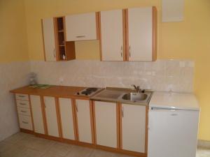 eine Küche mit weißen Schränken und einem Waschbecken in der Unterkunft Amber House Apartments Supetar-Brac in Supetar
