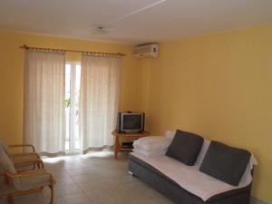 ein Wohnzimmer mit einem Sofa und einem TV in der Unterkunft Amber House Apartments Supetar-Brac in Supetar