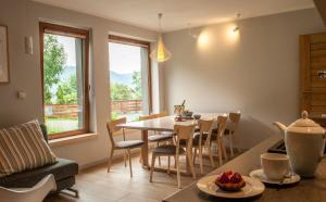 a kitchen and dining room with a table and chairs at Aspen Deluxe Residence & ASPEN cottage in Międzybrodzie Bialskie