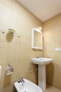 a bathroom with a sink and a toilet and a mirror at Apartamentos Santa Barbara in Alicante