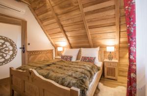 sypialnia z dużym łóżkiem i drewnianym sufitem w obiekcie willa TATIANA folk w Zakopanem