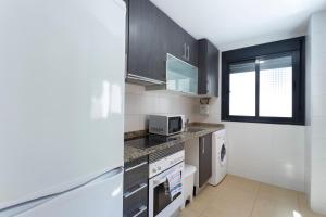 a kitchen with a stove top oven and a microwave at Apartamentos Santa Barbara in Alicante
